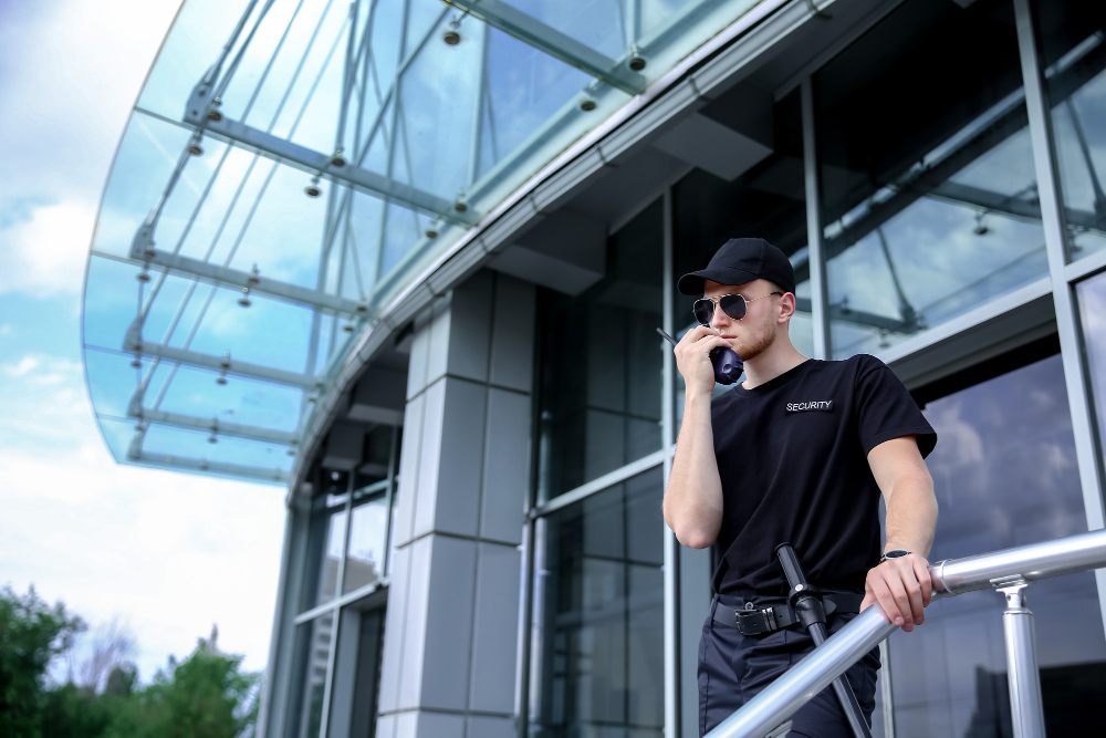 Sicherheitsmitarbeiter mit Funkgerät vor Firmengebäude — Vor-Ort Präsenz und Einsatzkoordination