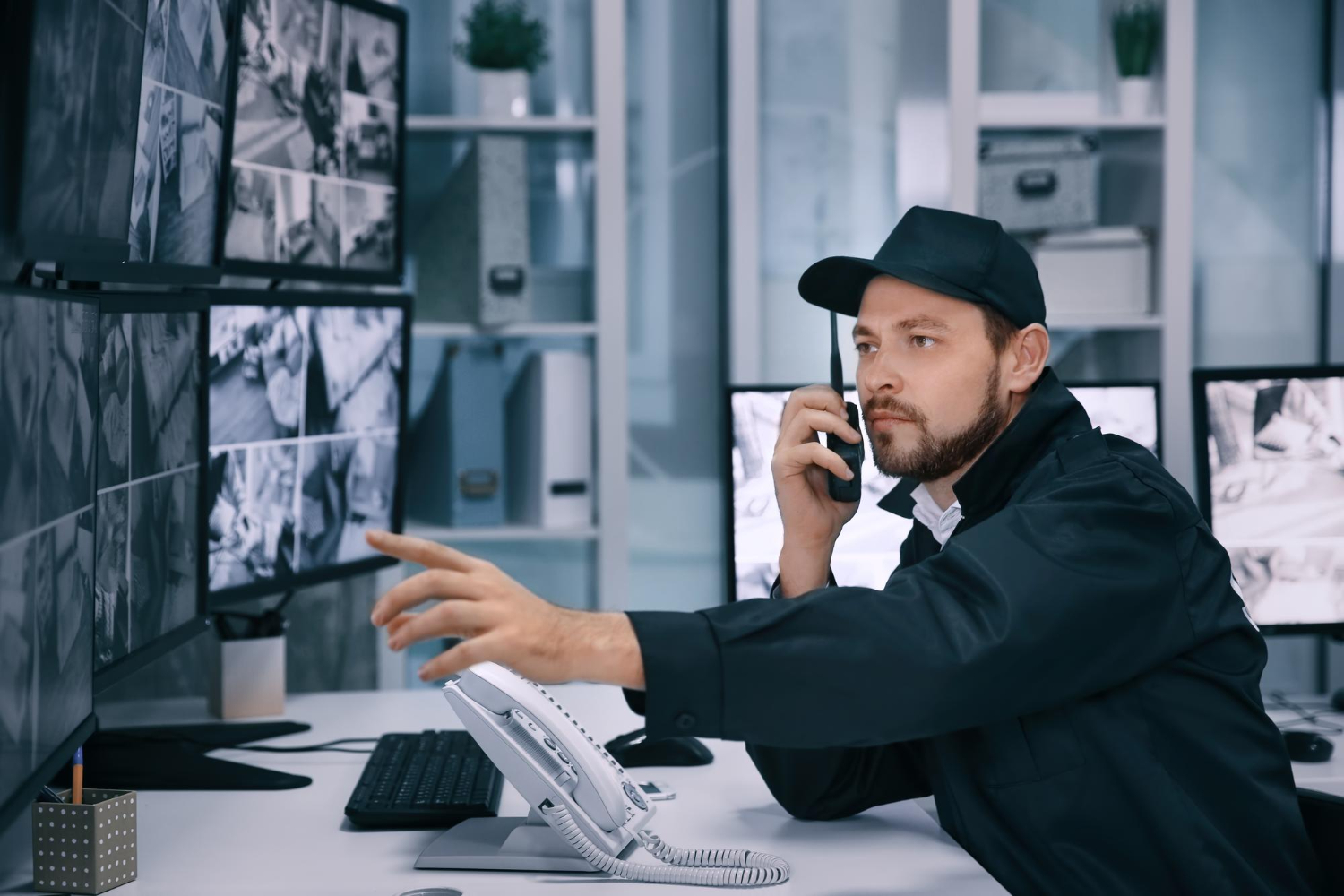 Leitstelle mit Monitoren und Einsatzleiter am Funkgerät